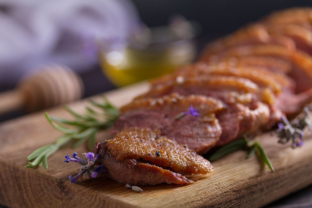 cooked duck breast sliced on a cutting board